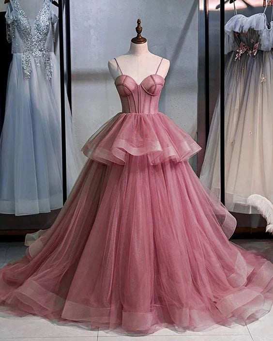 Woman wearing an elegant pink spaghetti strap floor-length evening dress.