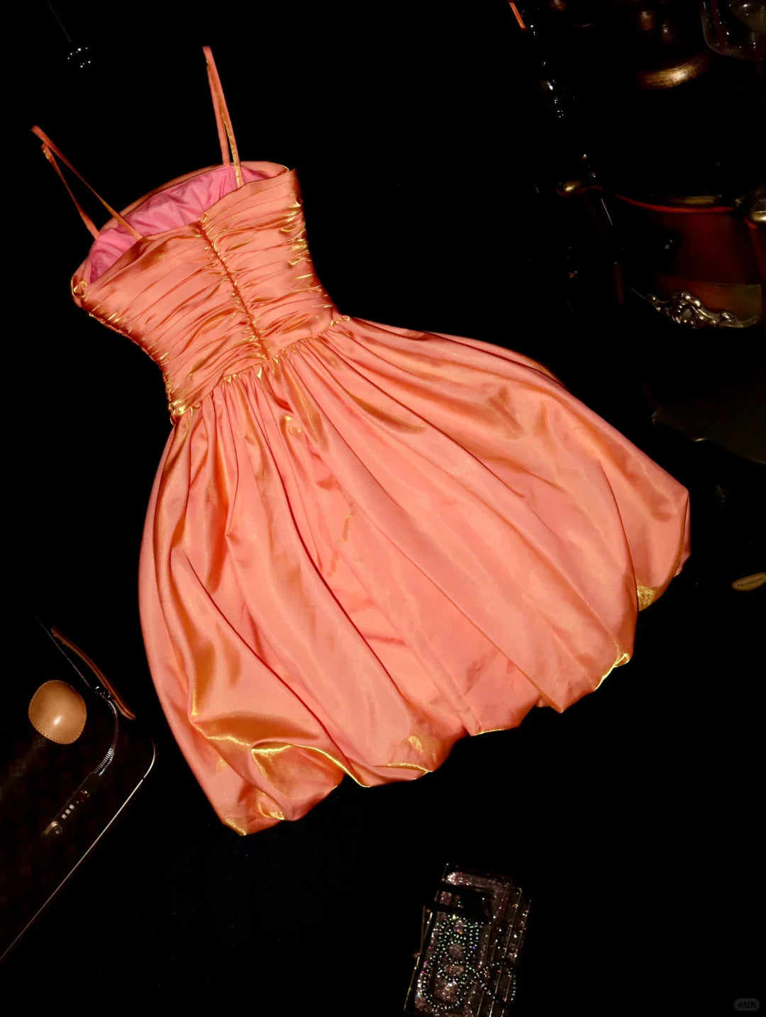 Back view of a short orange satin pleated dress, ideal for homecoming events.