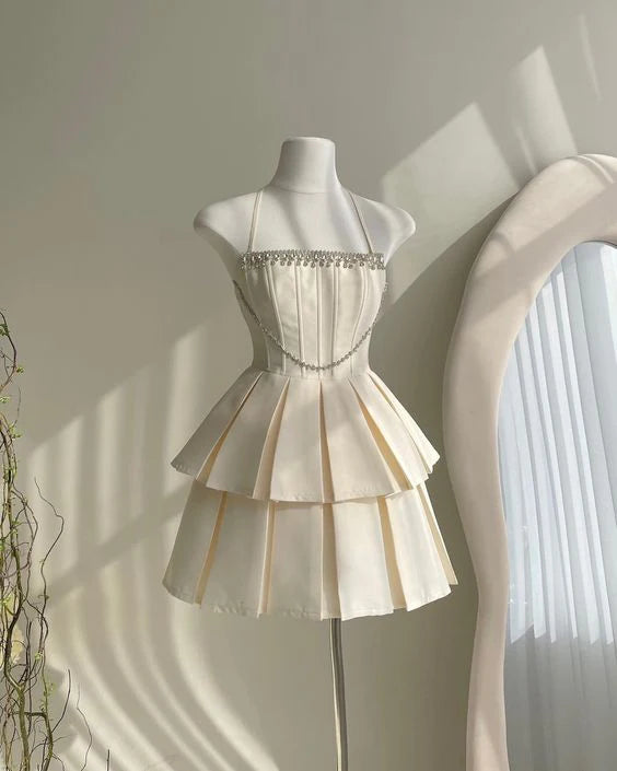 Model wearing a white A-line short homecoming dress with spaghetti straps and rhinestone trim.