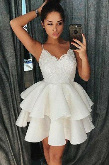 Model wearing a short satin A-line dress with spaghetti straps and lace.
