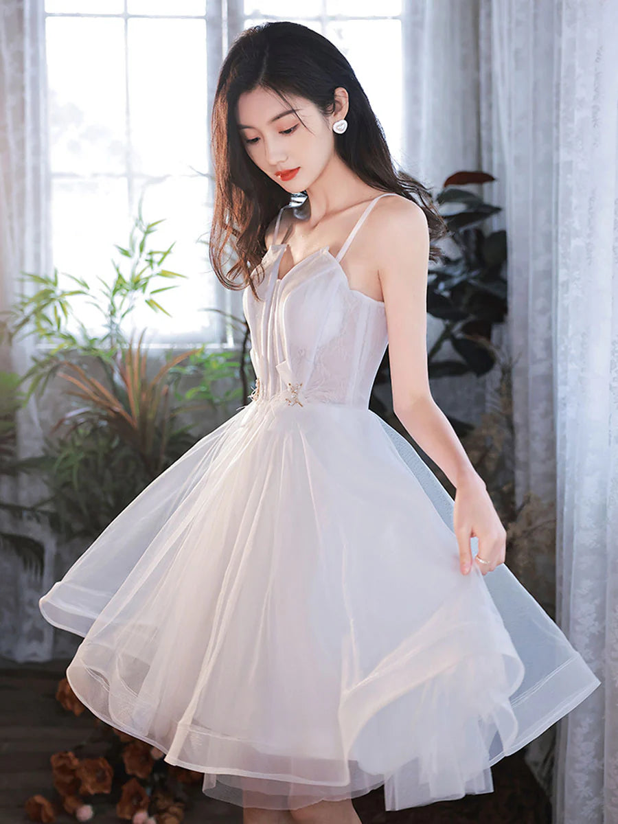 Side view of a white short tulle dress with spaghetti straps.