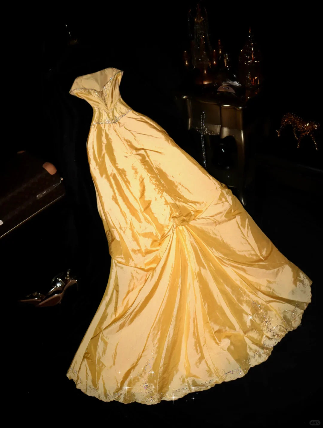 Back view of a yellow A-line strapless long party dress with shimmering embellishments.