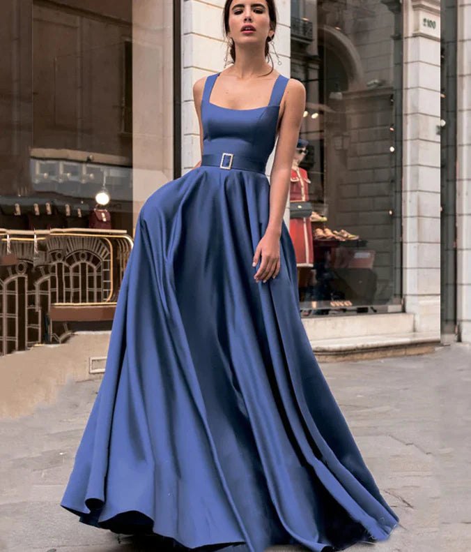 A woman wearing an elegant blue satin A-line strapless evening dress with criss-cross sashes, posing gracefully.