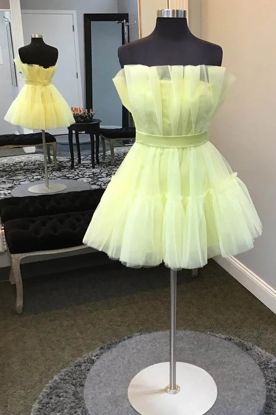 Light yellow A-line strapless off-shoulder tulle homecoming dress.