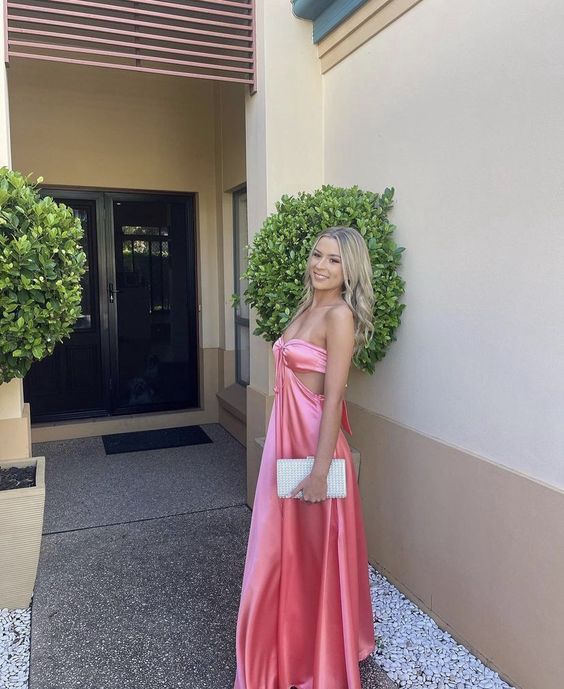Side view of a model posing in the elegant yellow strapless satin formal dress.