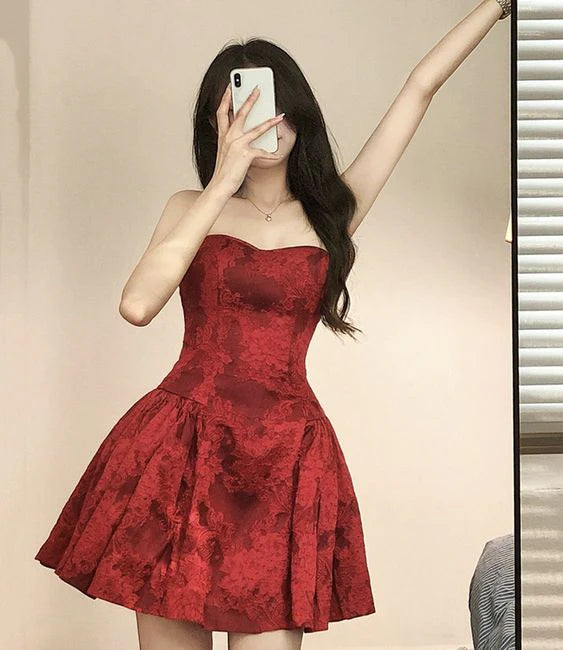 Woman wearing a red strapless A-line short homecoming dress with floral print.