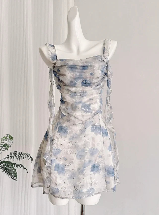 Model wearing an elegant blue floral A-line short homecoming dress with straps.