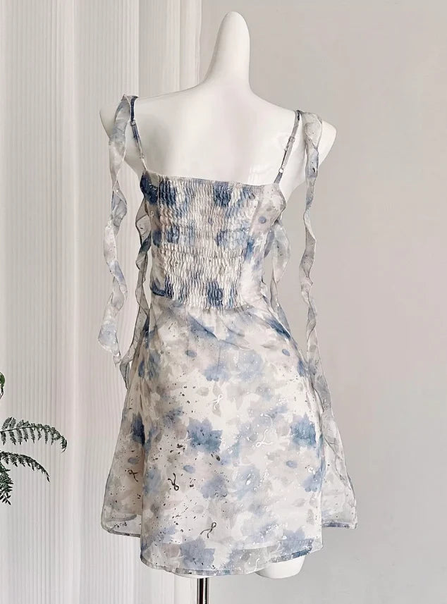 Back view of a model in a blue floral chiffon short party dress.