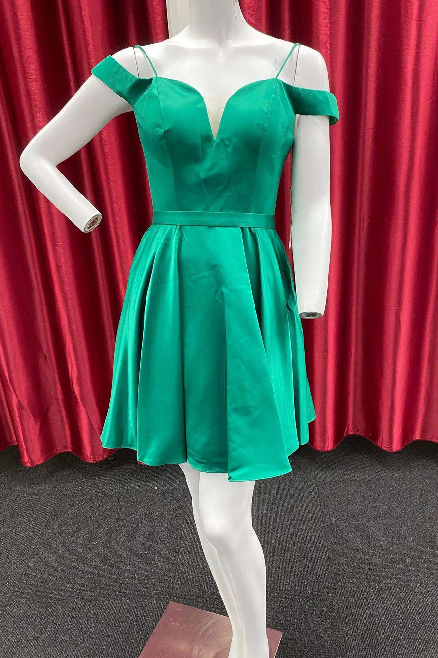 Model in a green A-line cold-shoulder homecoming dress, front view.