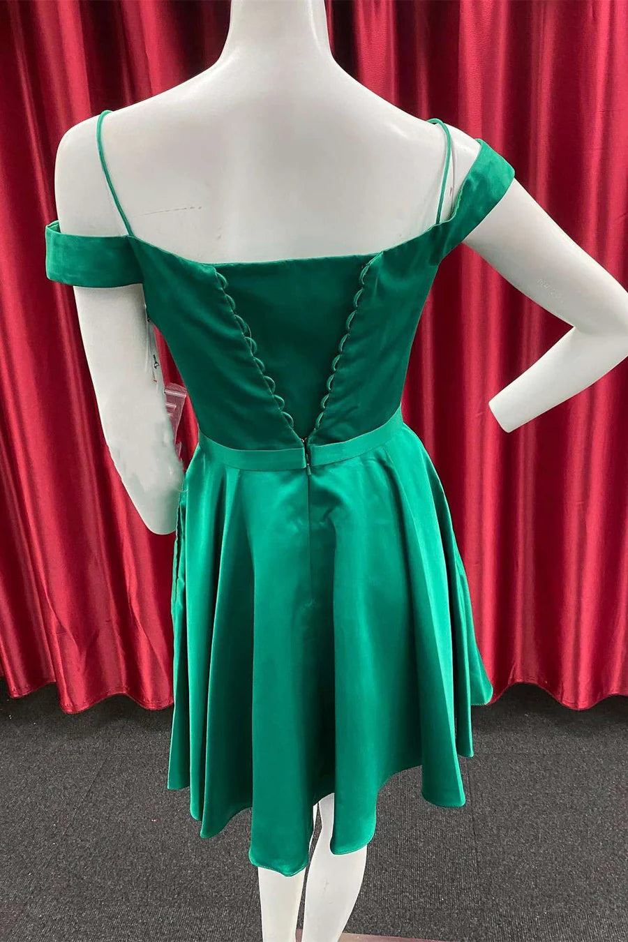 Model in a green A-line cold-shoulder homecoming dress, side view.