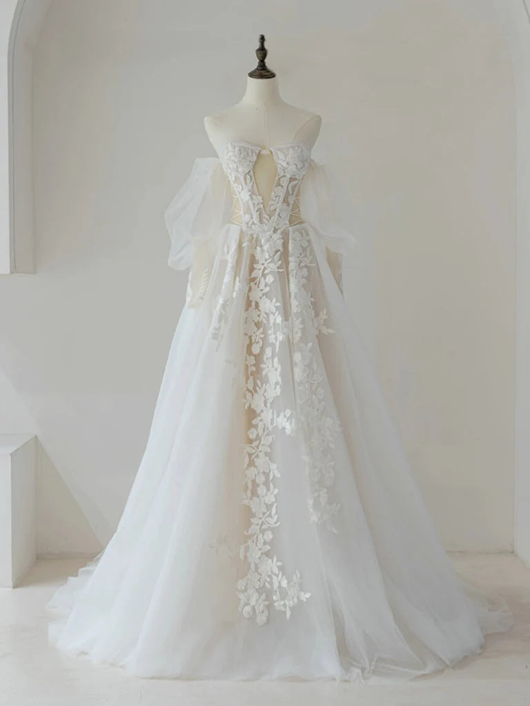 Model wearing a light champagne A-line lace tulle long prom dress, front view.