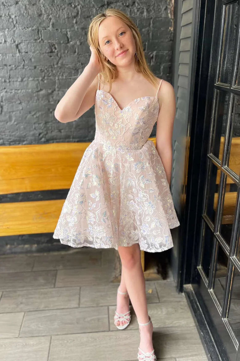 Front view of a woman wearing an elegant cream lace A-line short party gown with a sweetheart neckline.