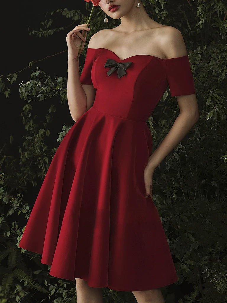 Side view of a woman in a pleated burgundy A-line homecoming dress.