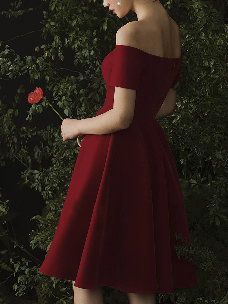 Back view of a woman showcasing a short burgundy party dress.