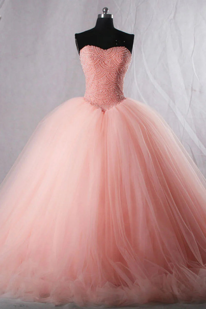 Model wearing a long pink sweetheart neck tulle beaded prom dress.