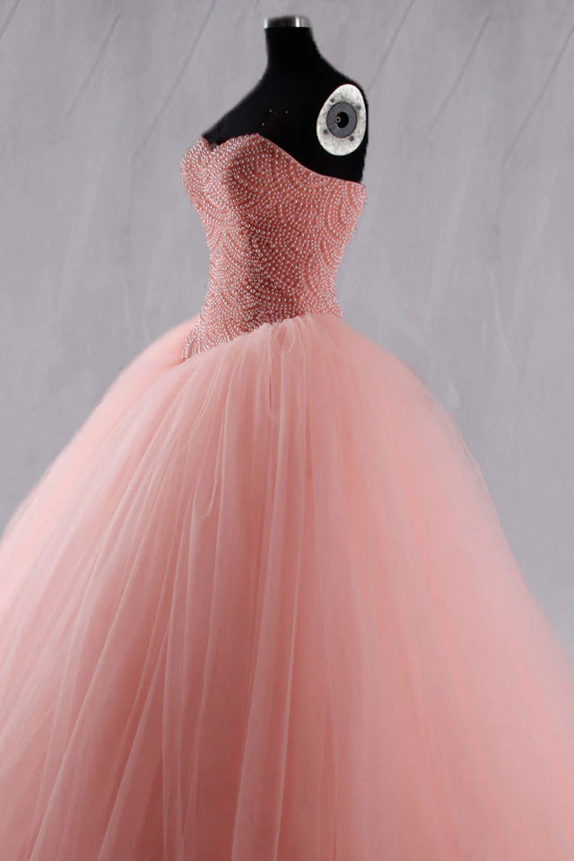 Side view of the pink sleeveless evening dress with bead details.
