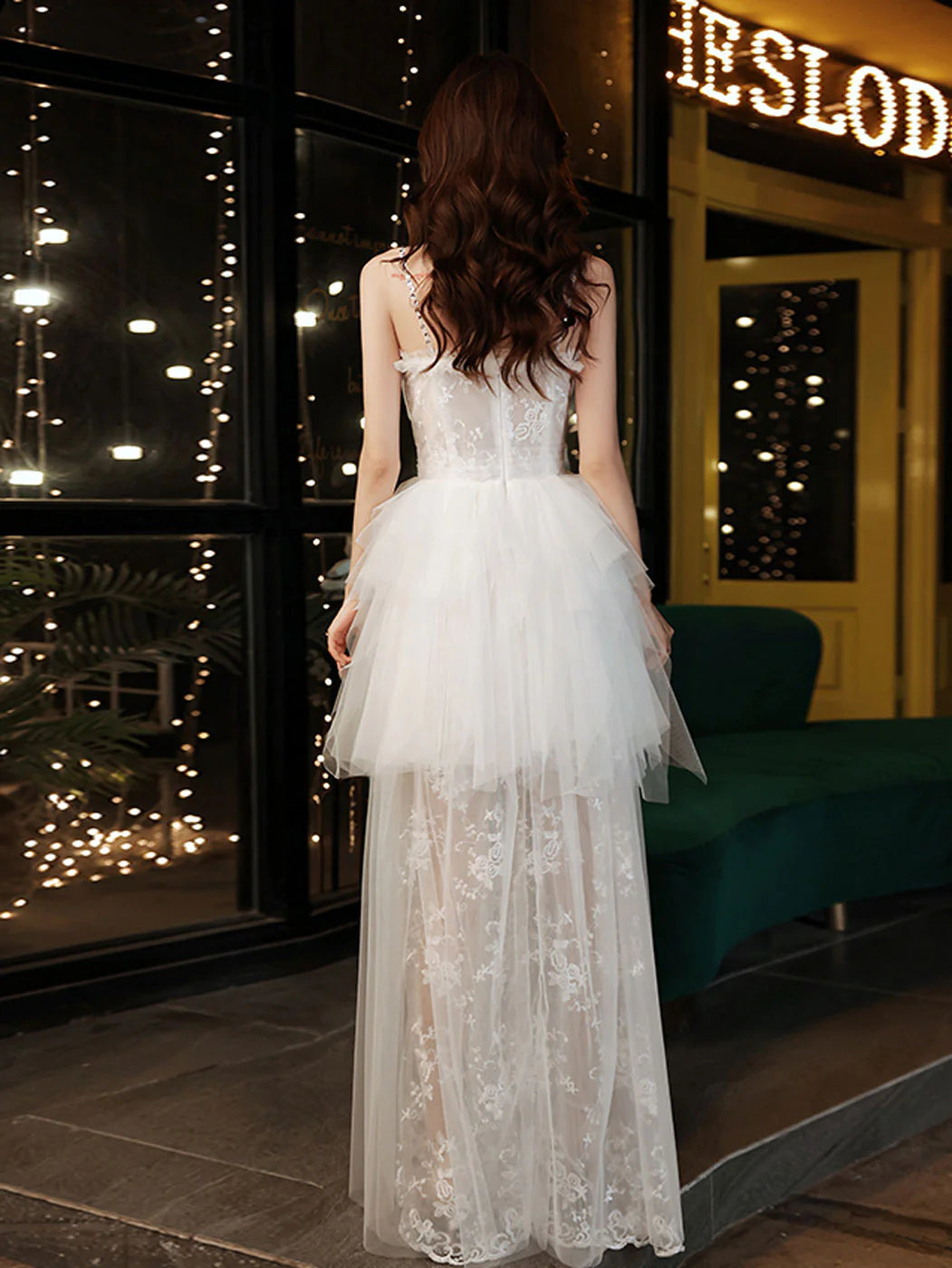 Back view of a white sweetheart neck long formal dress with flowing skirt.