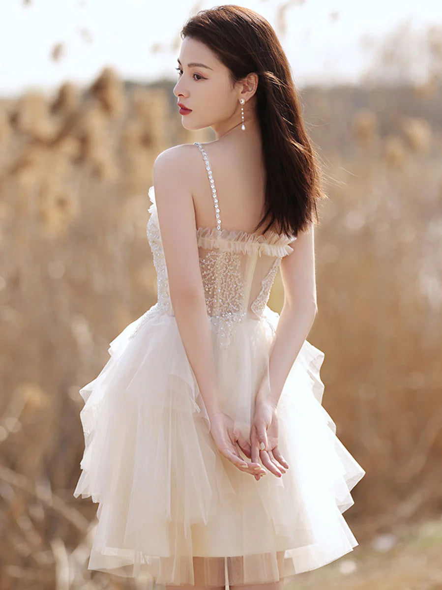 Full length view of a model in a beige sweetheart neck cocktail dress.