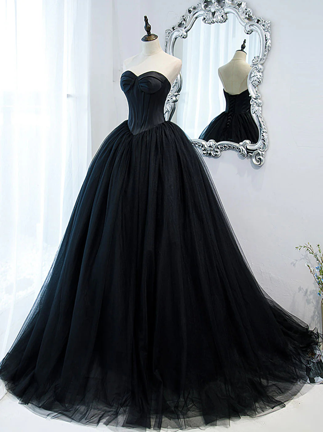 Side view of the black A-line tulle evening gown, showing the flowing skirt.