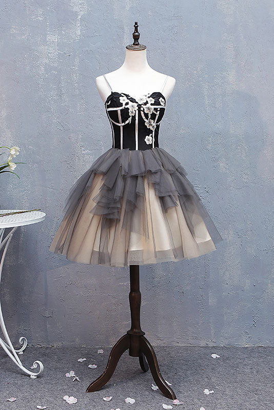 Woman wearing a black sweetheart neck short tulle prom dress.