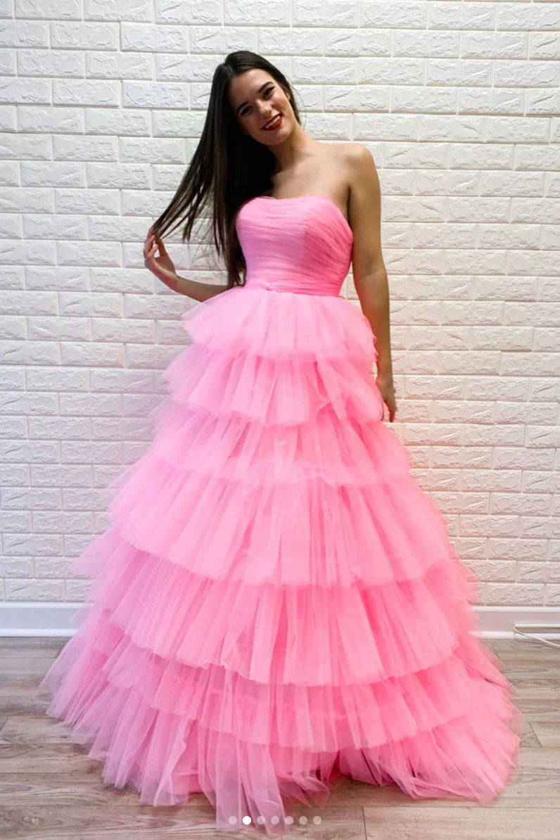 Full view of a woman wearing an elegant pink off-shoulder sweetheart tulle long prom dress.