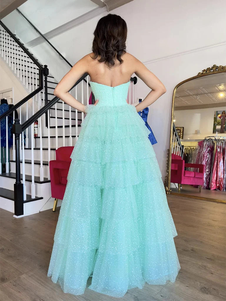 Model wearing an A-line sweetheart neck tulle blue long prom dress, side view.