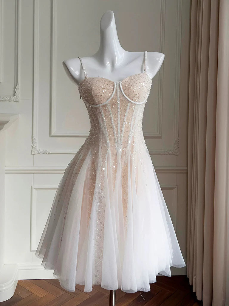 Model wearing a light champagne A-line short prom dress with sweetheart neck and sequins.