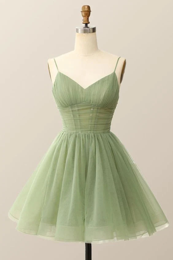 Young woman posing in a short A-line tulle homecoming dress with spaghetti straps and V-neck.
