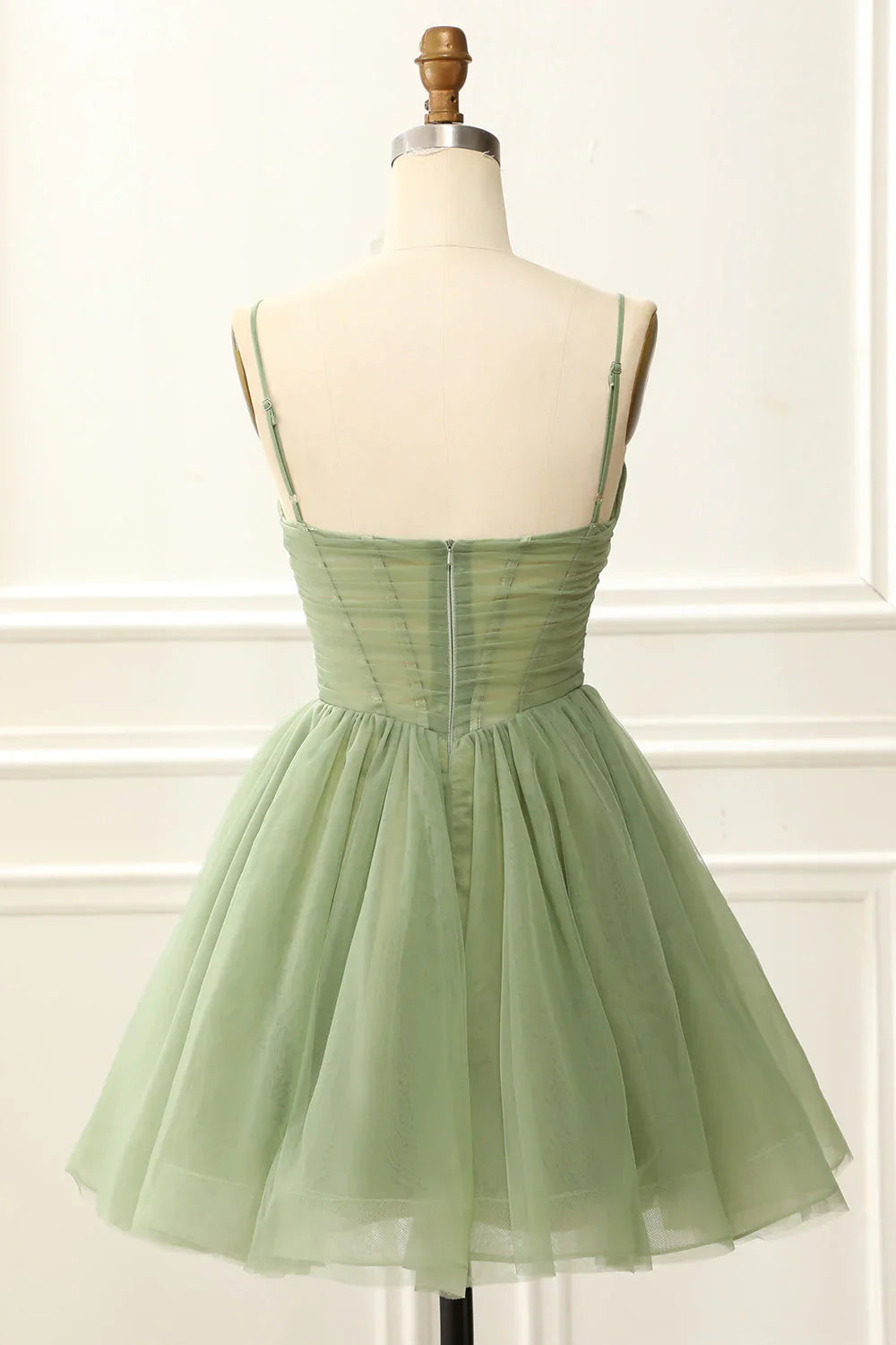 Model showcasing a short A-line tulle homecoming dress with spaghetti straps and V-neck.