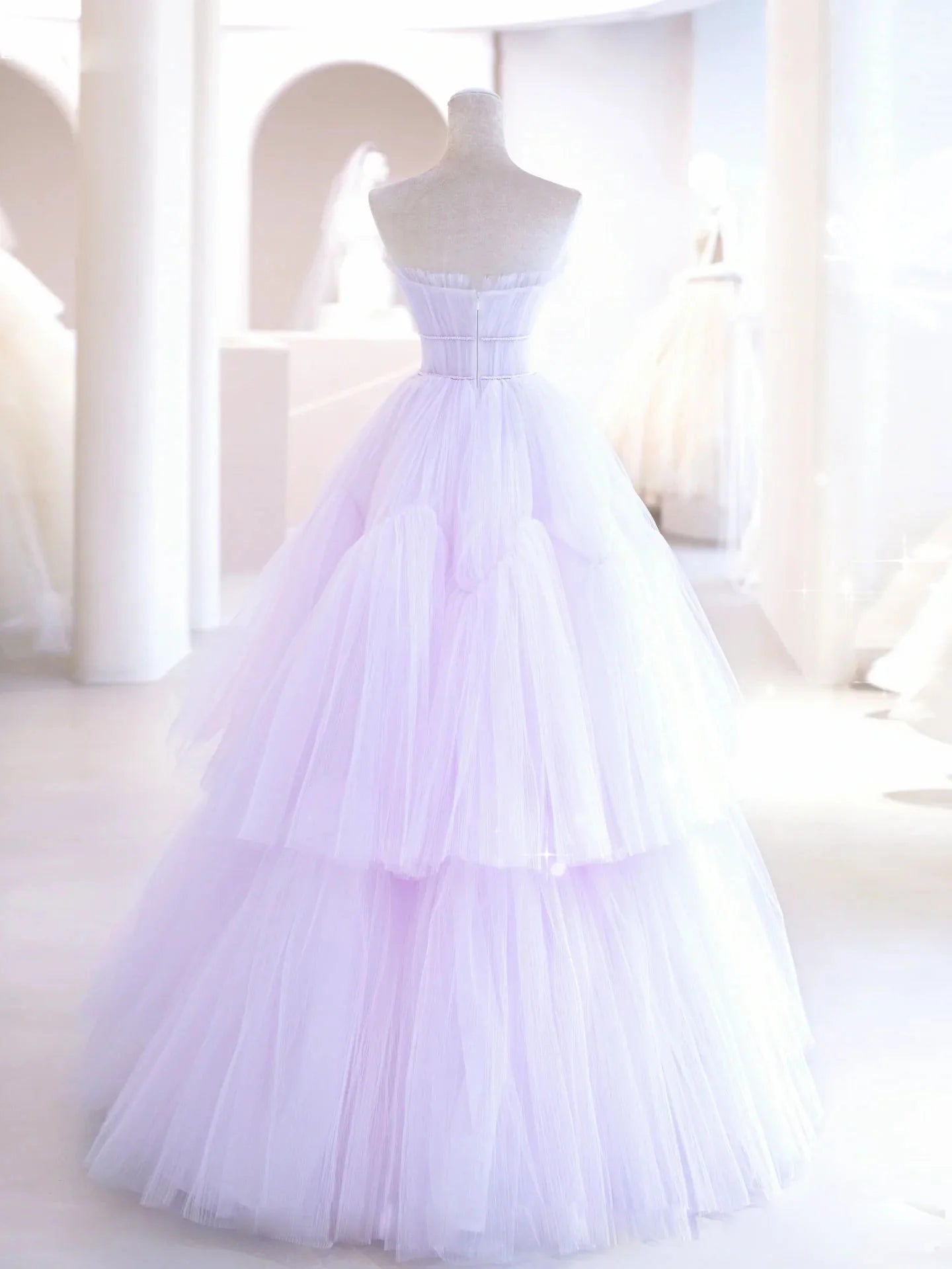 Full-length view of a woman in a flowing purple A-line evening gown.