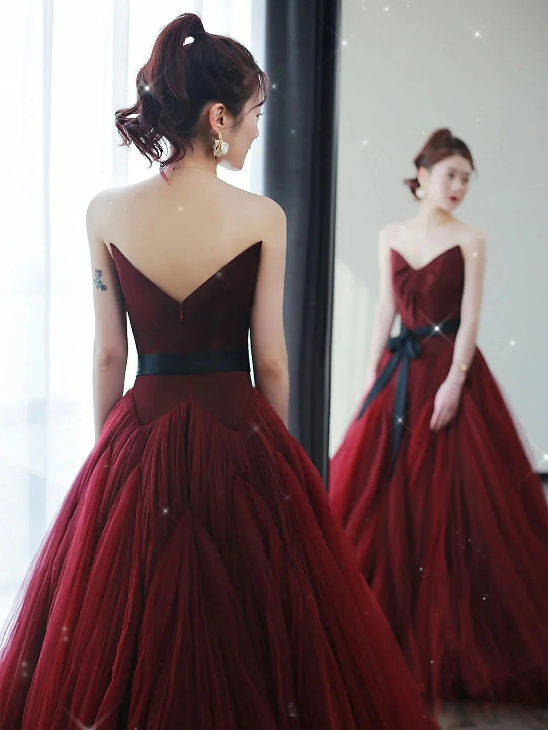 Elegant A-line burgundy tulle long prom dress on a model.