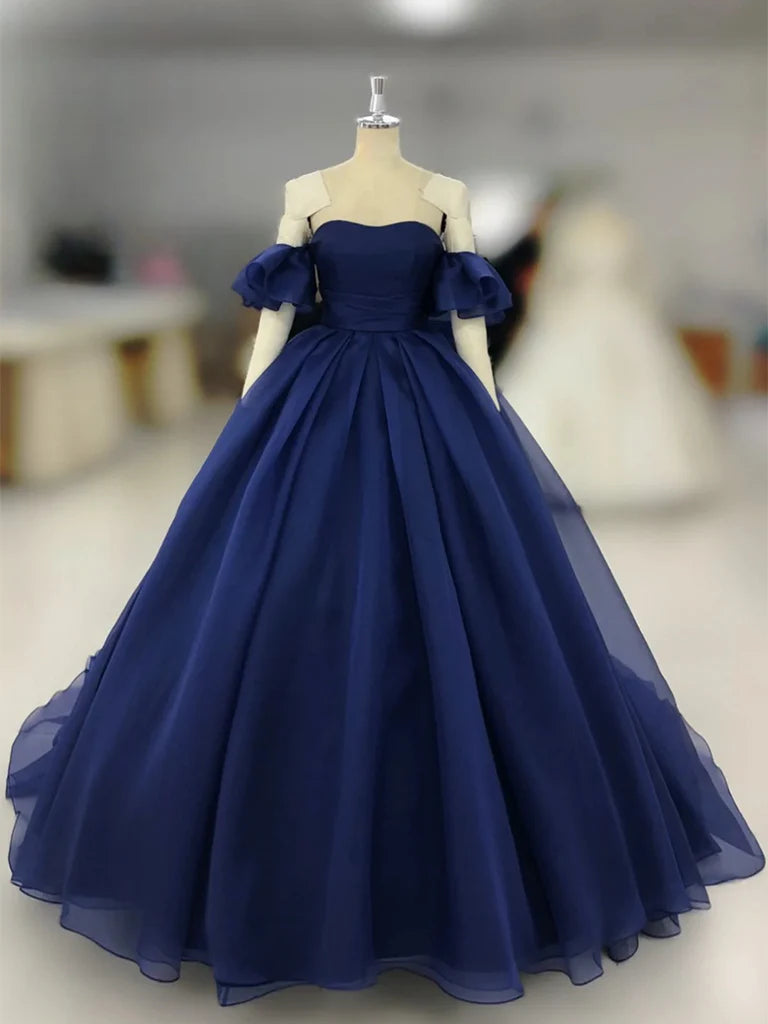 Model wearing a dark blue A-line tulle long prom dress, front view.