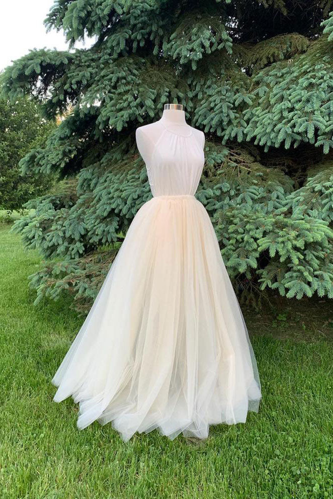 Woman wearing a light champagne long tulle prom dress.