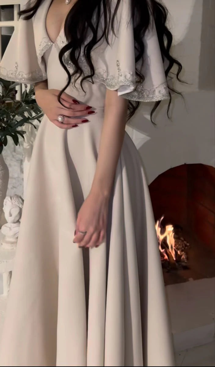 Woman posing gracefully in a black A-line evening dress.