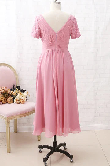 Close-up of the V-neckline and intricate beaded sleeves on the pink chiffon gown.