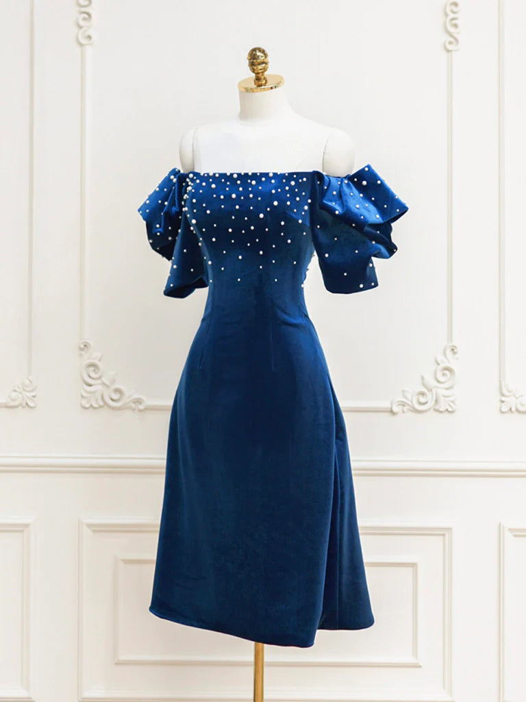 Woman wearing a blue velvet short prom dress with beaded details.