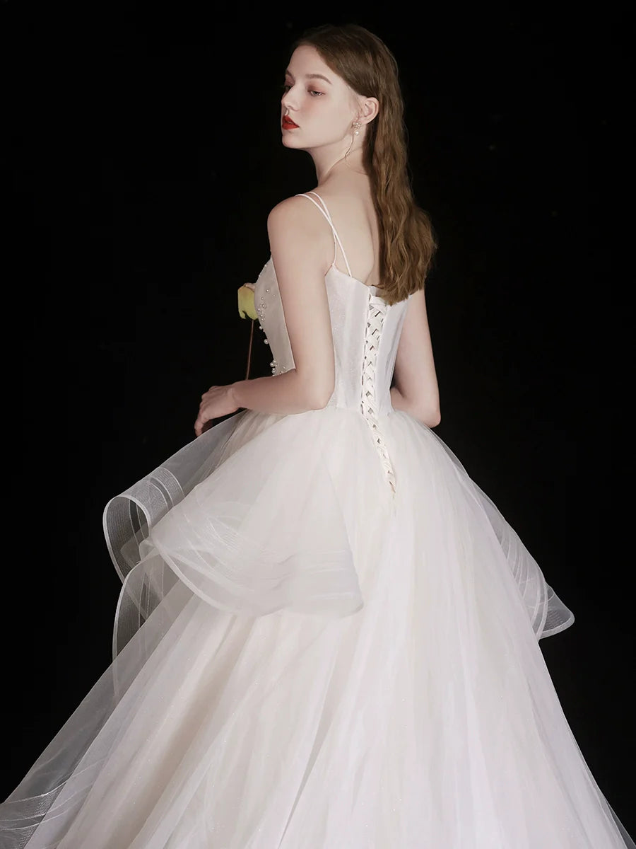 Close-up of the intricate beading on the V-neck bodice of the white tulle dress.