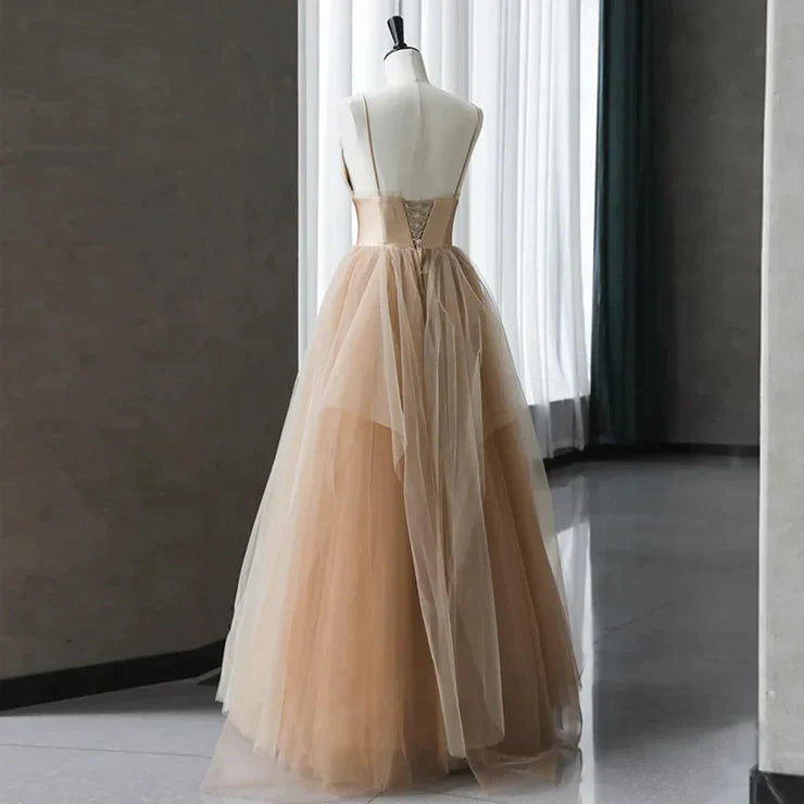 Close-up of the champagne gradient tulle fabric and delicate straps on an evening gown.
