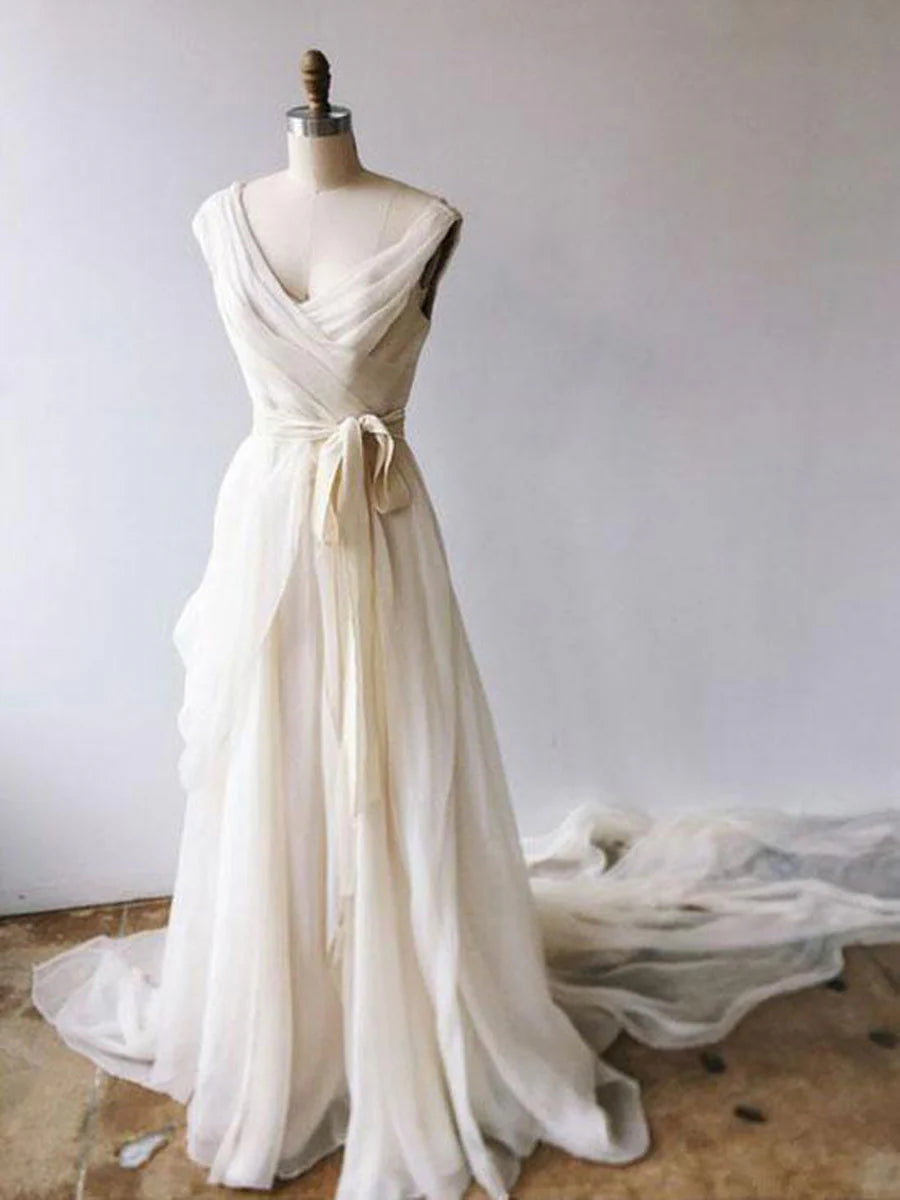 Elegant ivory chiffon A-line gown with V-neck and sash belt, worn by a model outdoors.