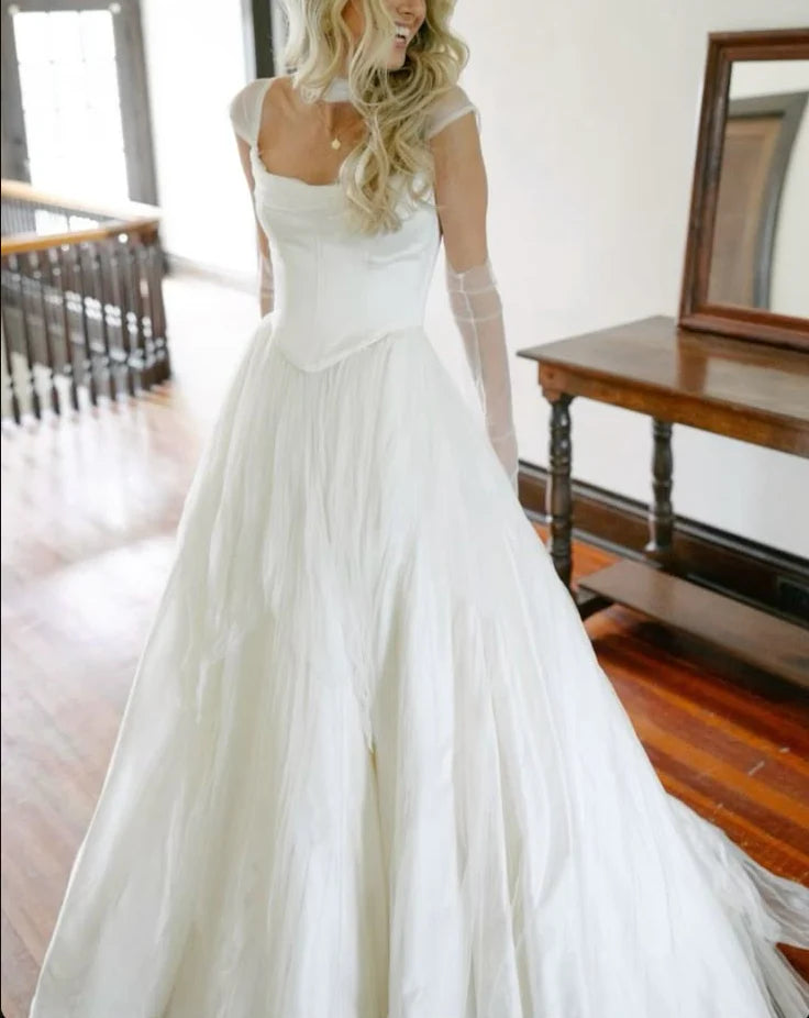 Full-length view of an elegant white chiffon A-line wedding dress.