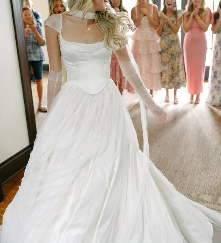 White chiffon wedding dress with flowing floor-length skirt.