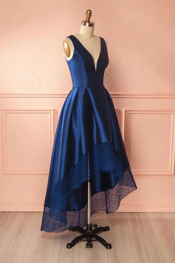 Model posing in a dark blue formal high-low gown.