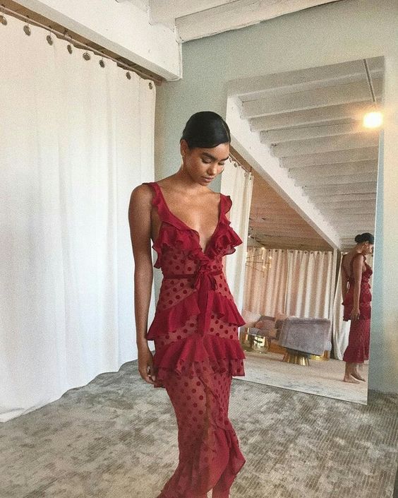 Woman wearing an elegant burgundy polka dot A-line V-neck prom dress.