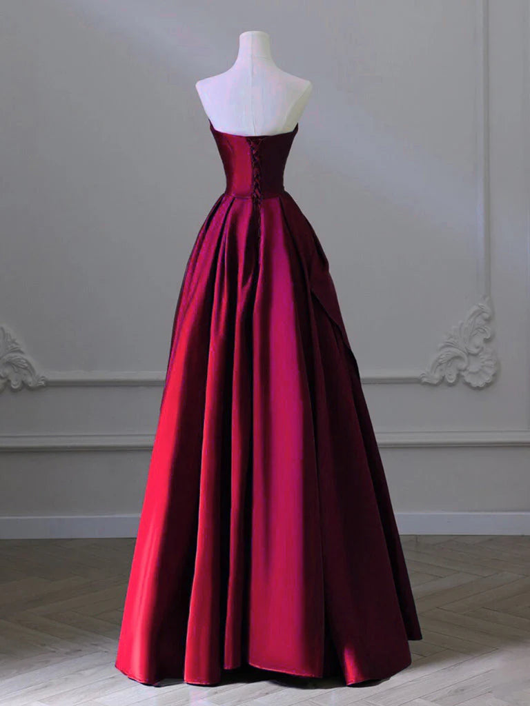 Side view of a model in a burgundy A-line satin formal dress.