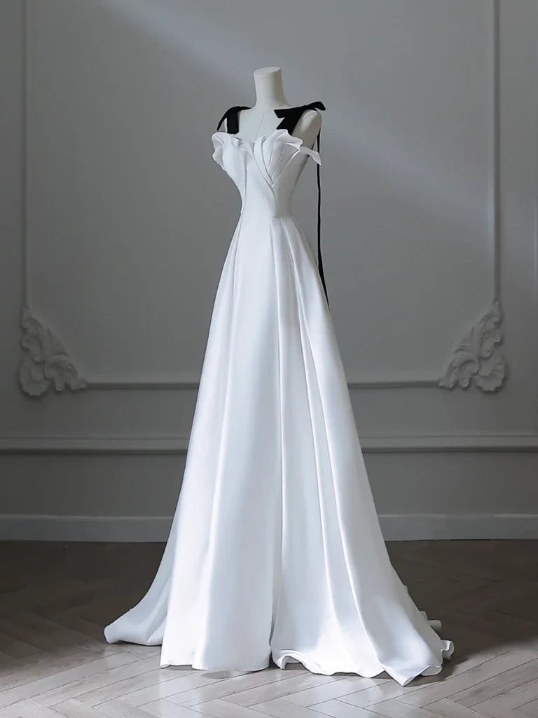 Model in a flowing white A-line satin formal gown, side view.