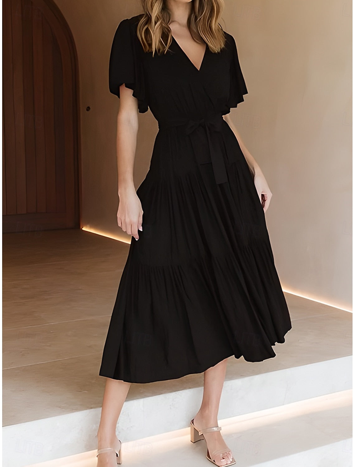 Woman wearing an elegant solid A-line V-neck short sleeve maxi dress, back view.