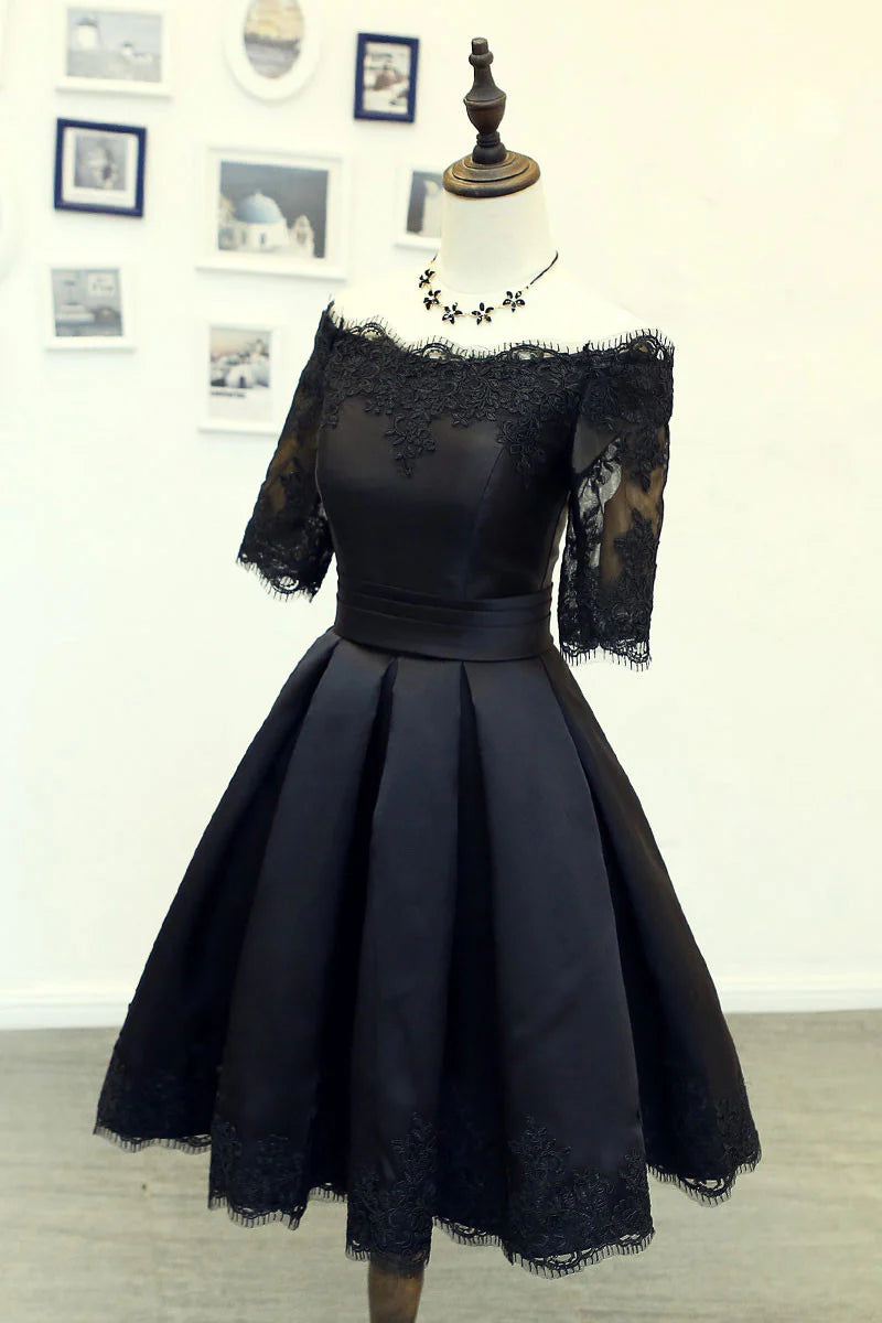 Woman wearing an elegant black lace short prom dress, front view.