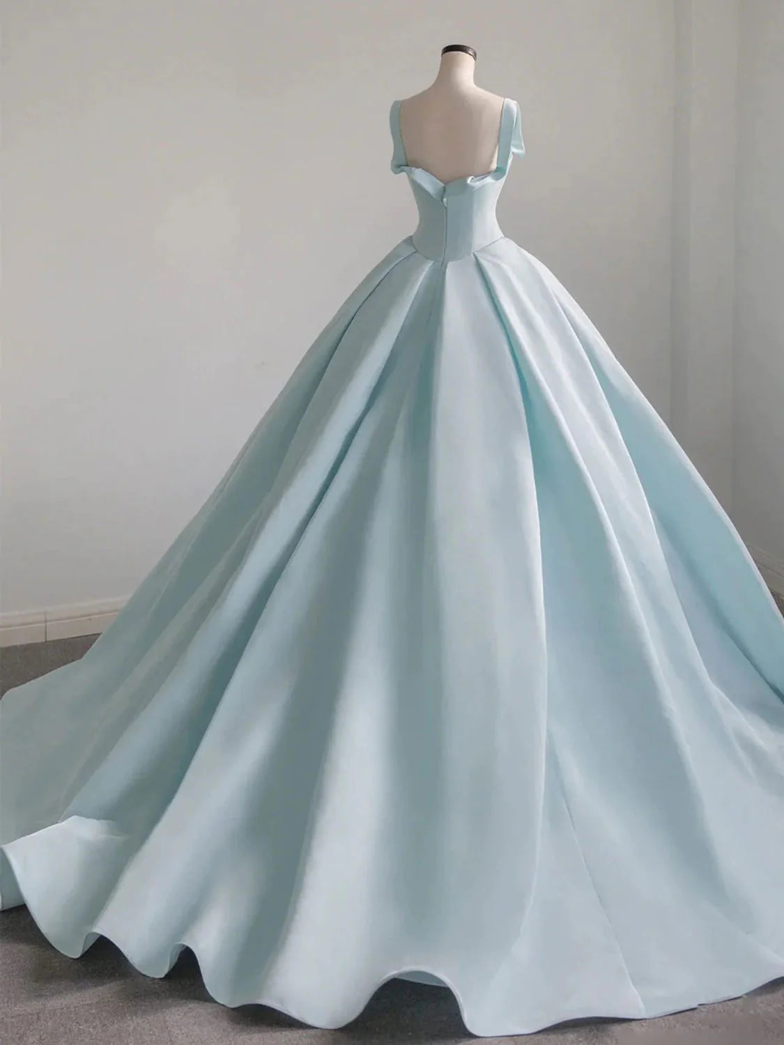 Model showcasing the back and sweep train of the blue satin evening gown.