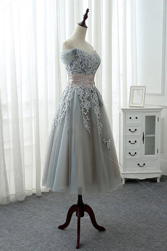 Side view of a gray lace tulle evening gown, showcasing the flowing skirt.