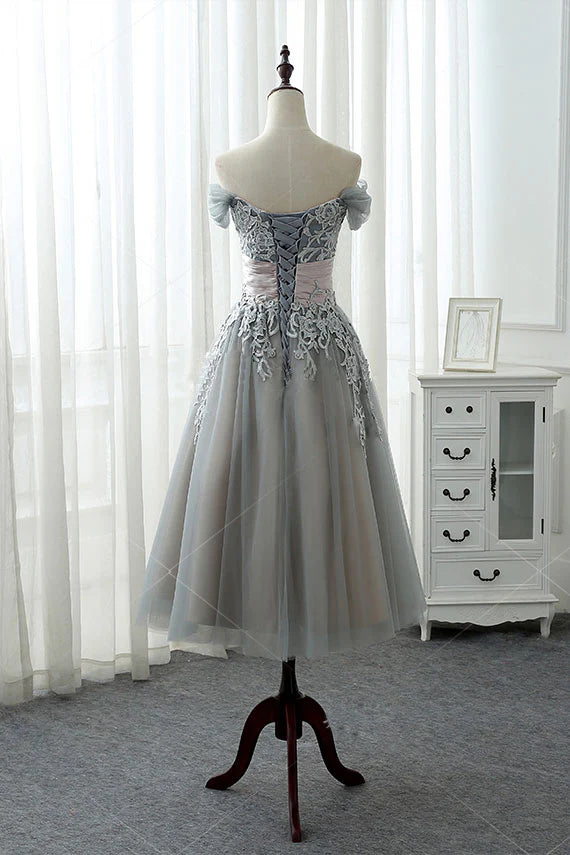 Close-up of the delicate gray lace and soft tulle fabric on the dress.